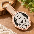 Snoopy key fob machine embroidery design featuring smiling Snoopy face with black ears and decorative keychain outline