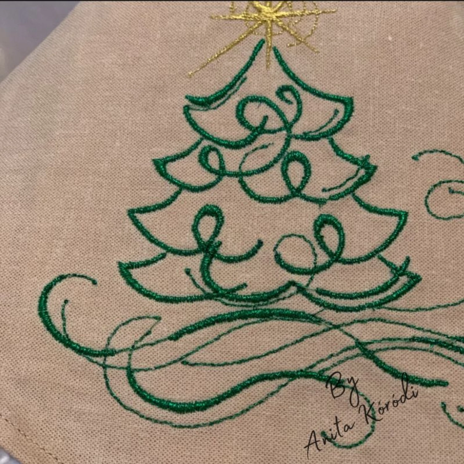 Green Christmas tree embroidery with decorative swirls and star